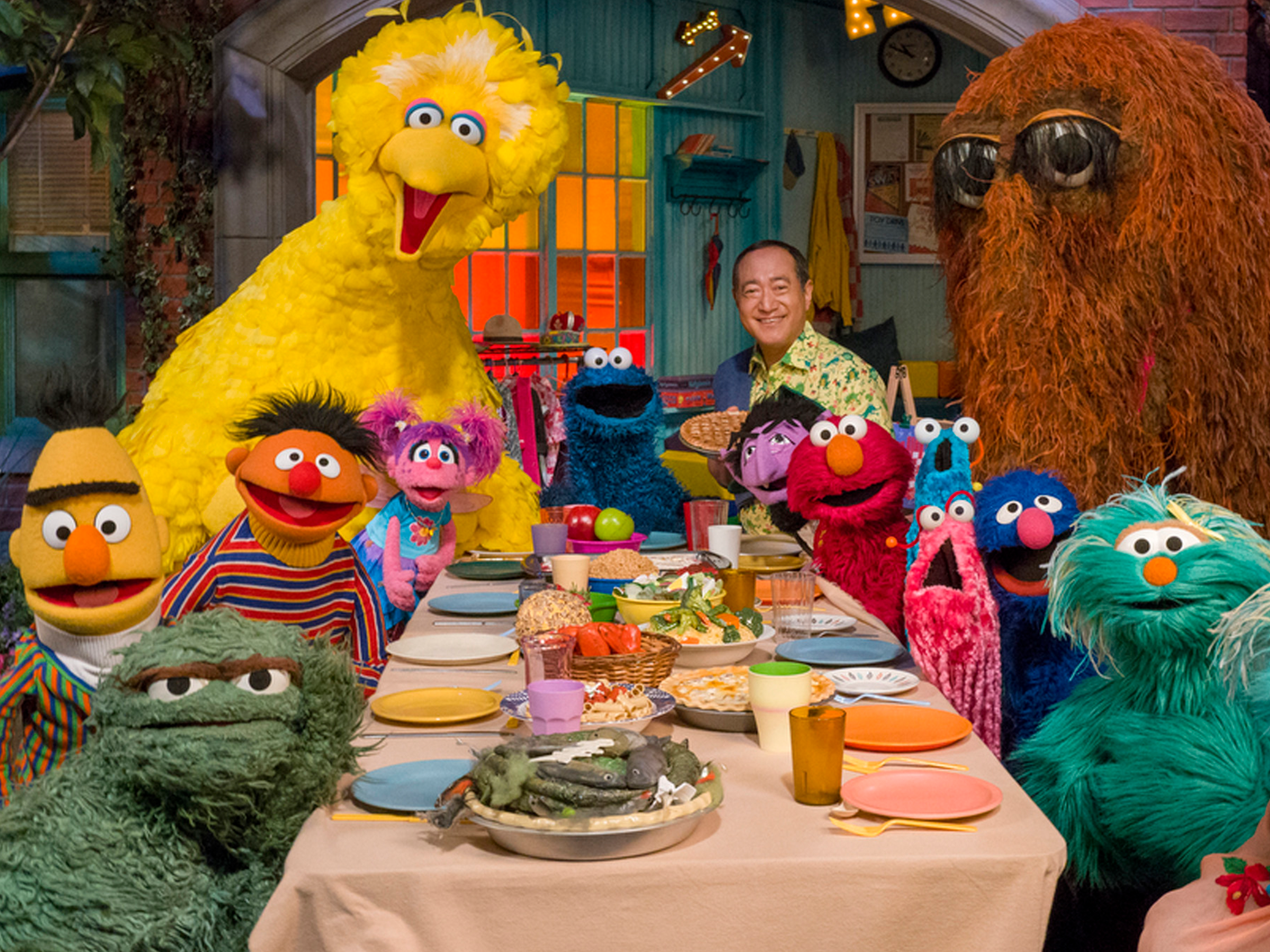 An image of the cast of Sesame Street sitting at a birthday table.