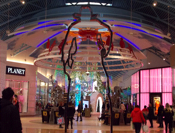 A large metal outline of a cowboy, wiht a hand on his gun and poised to fire. Behind him is the sun display.